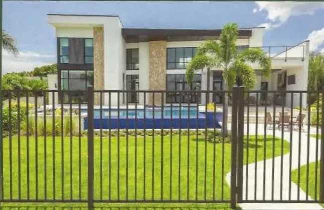 Black flat-top aluminum fence installed around a pool and patio