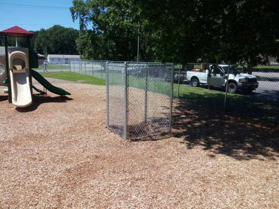 Galvanized chain link perimeter and equipment enclosure at a playground