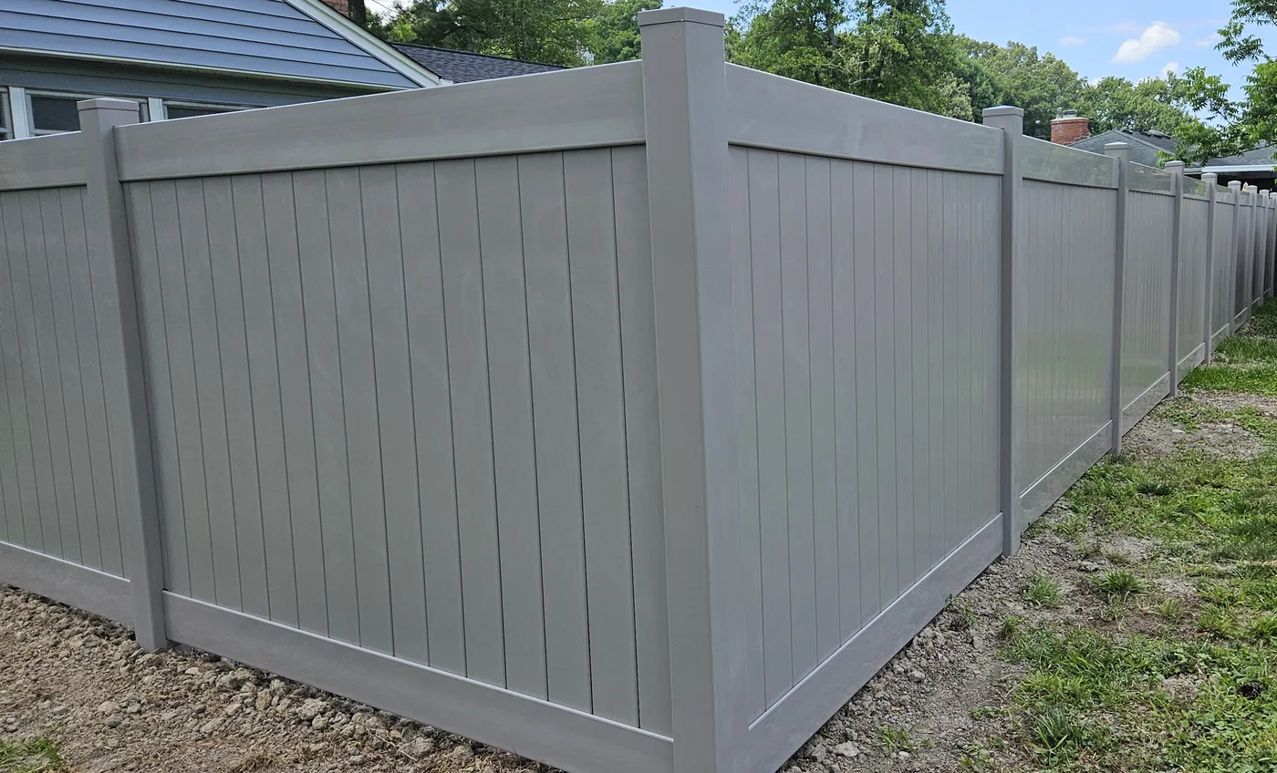 Gray vinyl privacy fence corner, clean lines and capped posts