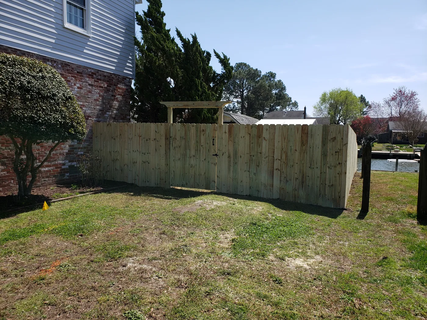Wood privacy fence with a standard pergola top gate built by VB Fences