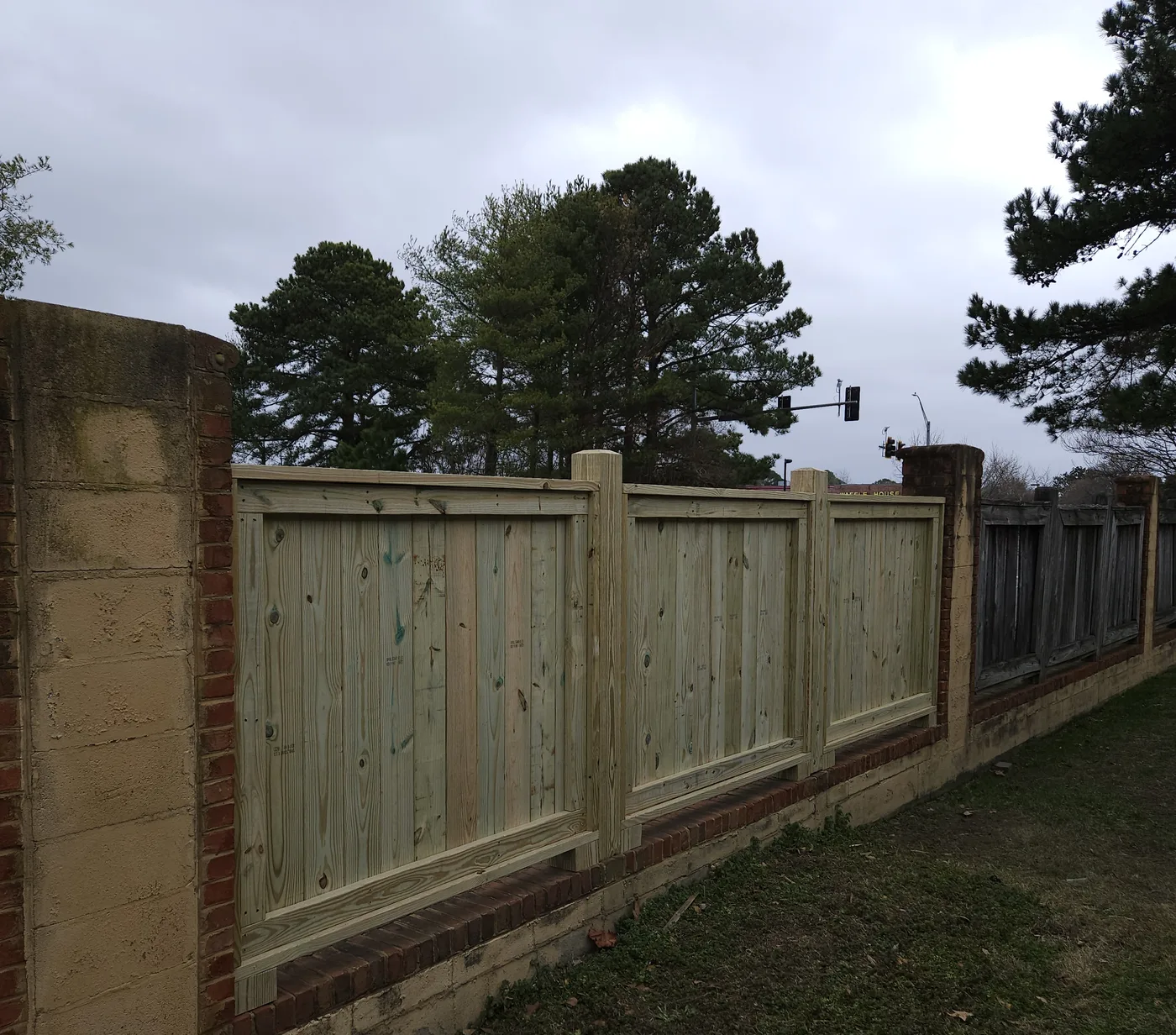 Custom framed wood fence sections built on site between masonry pillars by VB Fences