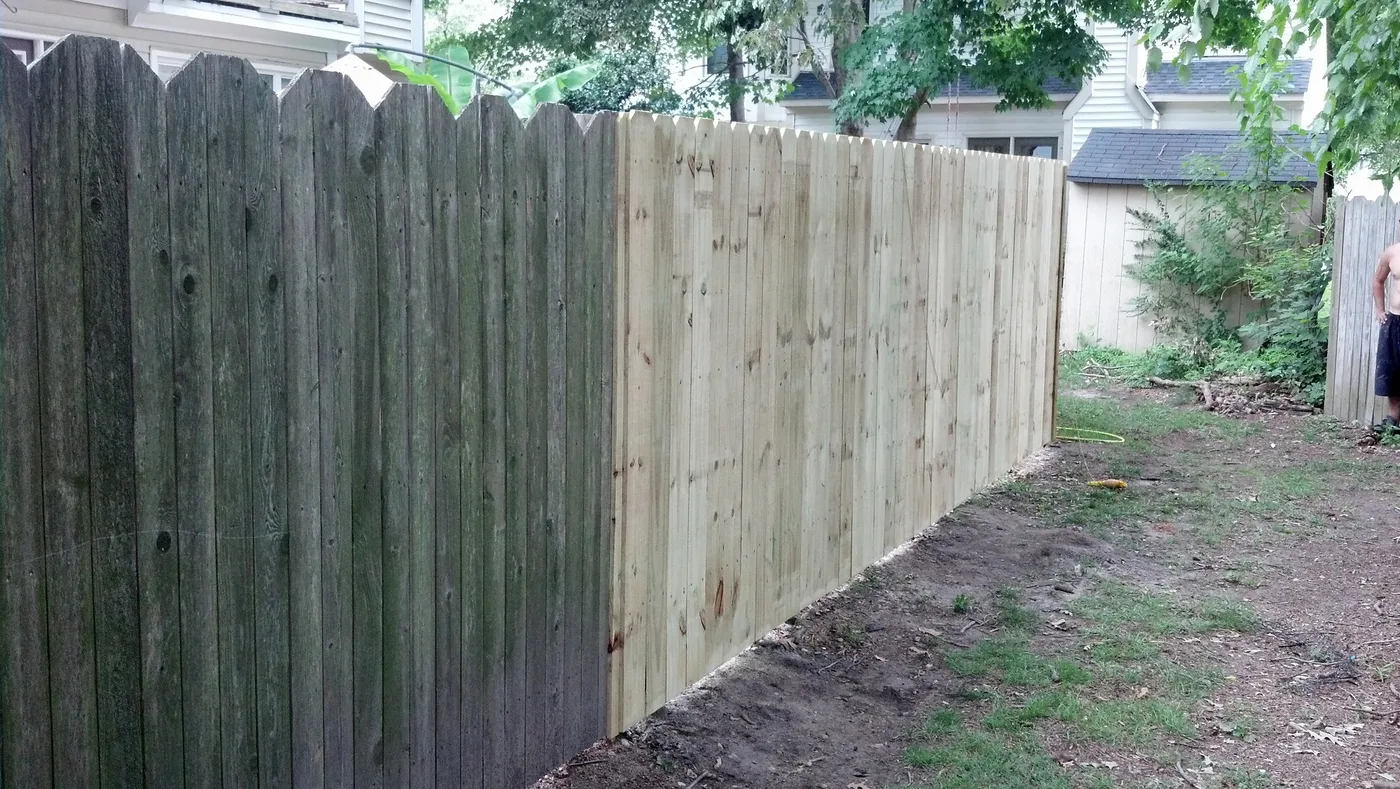 Fence repair in progress: new replacement sections installed against the original weathered fence line