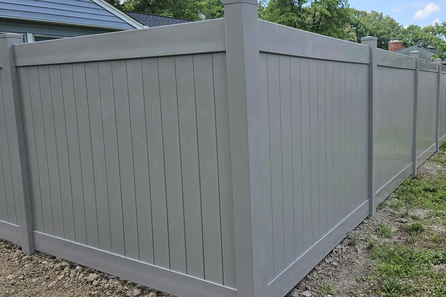 White vinyl privacy fence around a backyard